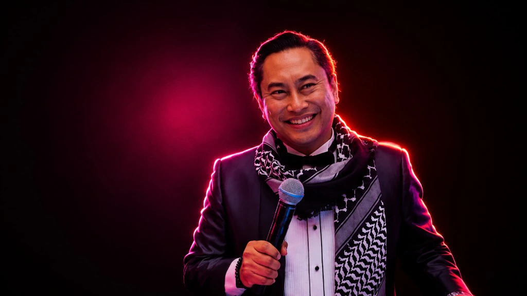 Eswan Eshak — pengacara majlis dengan mikrofon, berpakaian rasmi